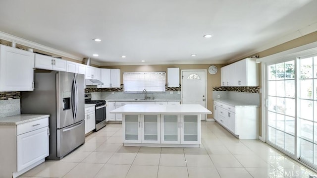 kitchen featuring white cabinetry, sink, decorative backsplash, a kitchen island, and appliances with stainless steel finishes