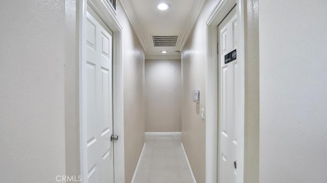 hall featuring ornamental molding and light tile patterned floors