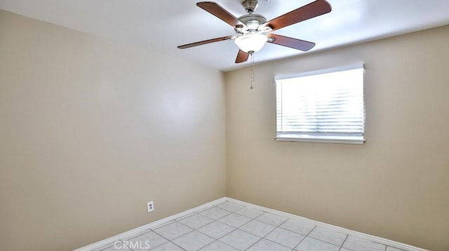 spare room with ceiling fan and light tile patterned floors