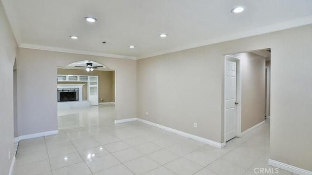 spare room with ceiling fan, light tile patterned floors, and ornamental molding