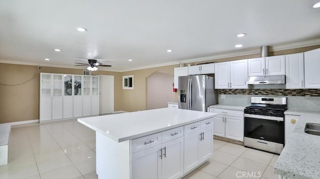 kitchen featuring decorative backsplash, ceiling fan, a kitchen island, white cabinetry, and stainless steel appliances