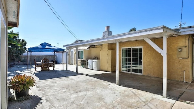 rear view of house with a gazebo and a patio