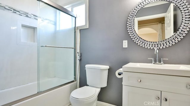 full bathroom with vanity, bath / shower combo with glass door, and toilet