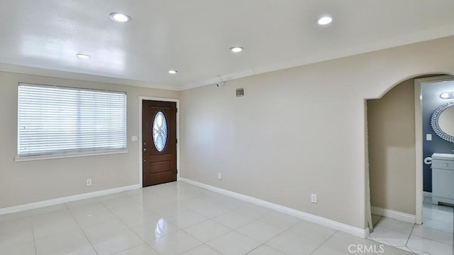 entryway featuring light tile patterned flooring and ornamental molding