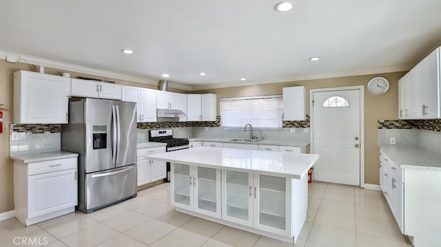 kitchen with appliances with stainless steel finishes, white cabinetry, a kitchen island, and sink