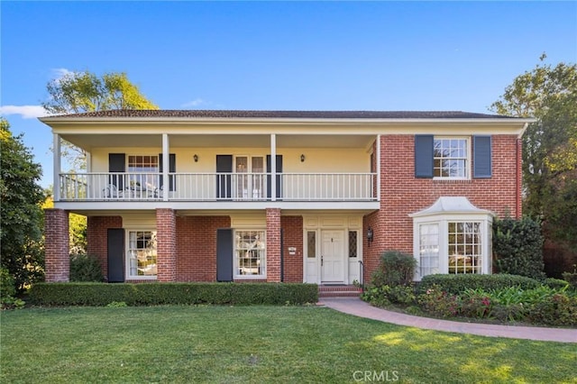 view of front of property featuring a front yard and a balcony