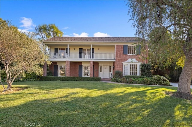 view of front of property featuring a balcony and a front lawn