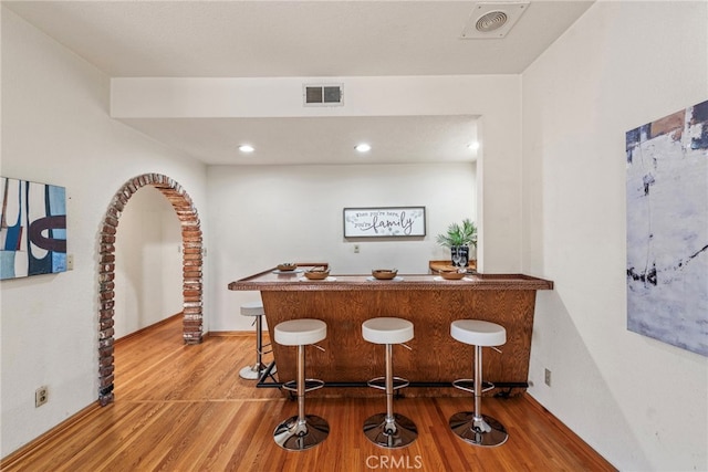 bar with hardwood / wood-style floors