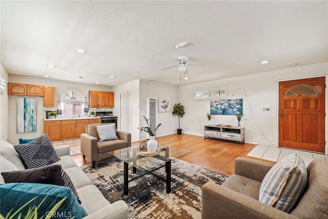 living room featuring ceiling fan and light hardwood / wood-style flooring