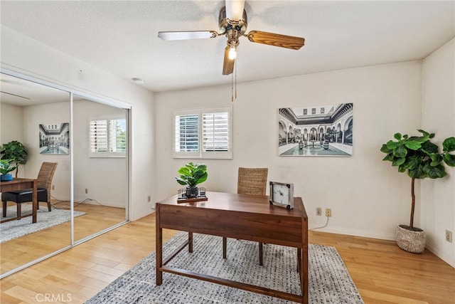 home office with hardwood / wood-style floors and ceiling fan