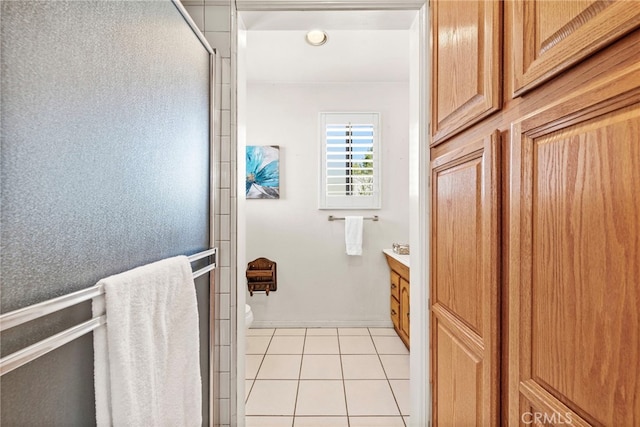 bathroom with tile patterned flooring, vanity, toilet, and a shower with shower door