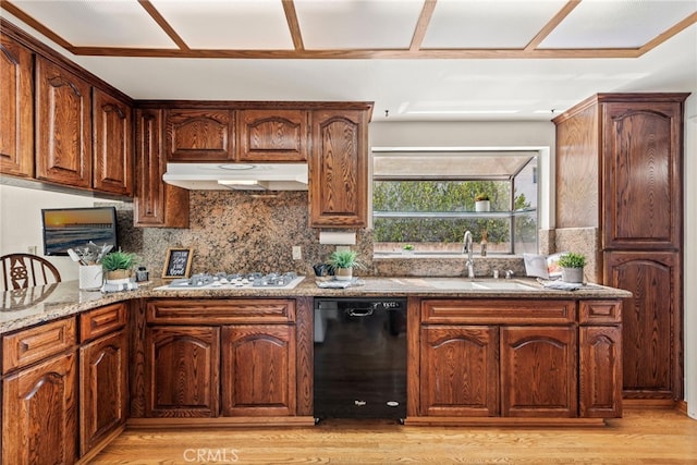 kitchen featuring black dishwasher, light hardwood / wood-style floors, tasteful backsplash, and white gas stovetop