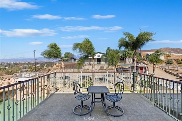 view of patio with a mountain view and a balcony