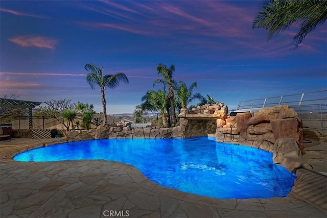 pool at dusk featuring a patio