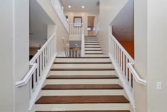 stairway featuring a high ceiling