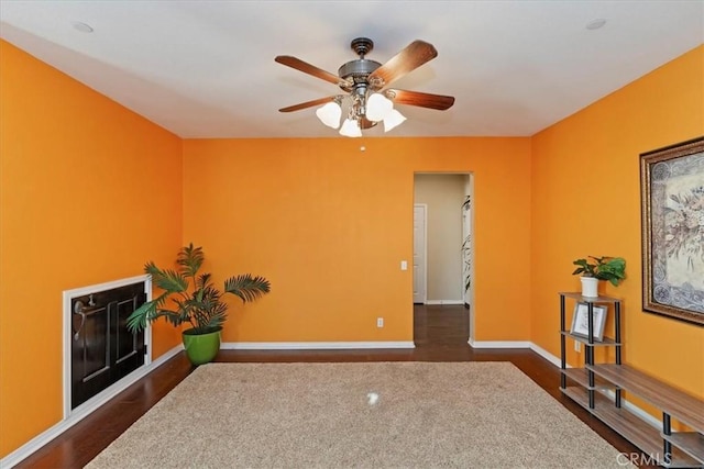 living area with dark hardwood / wood-style flooring and ceiling fan