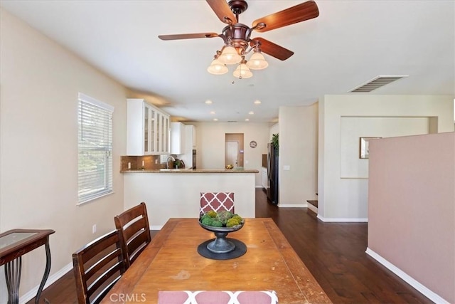 dining room with ceiling fan and dark wood-type flooring