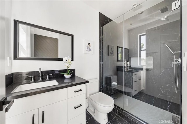 bathroom with vanity, toilet, and a shower with shower door