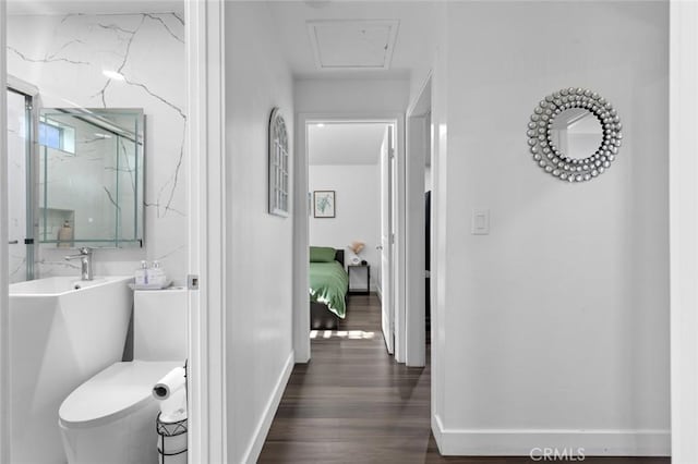 bathroom featuring wood-type flooring, toilet, and a shower with door