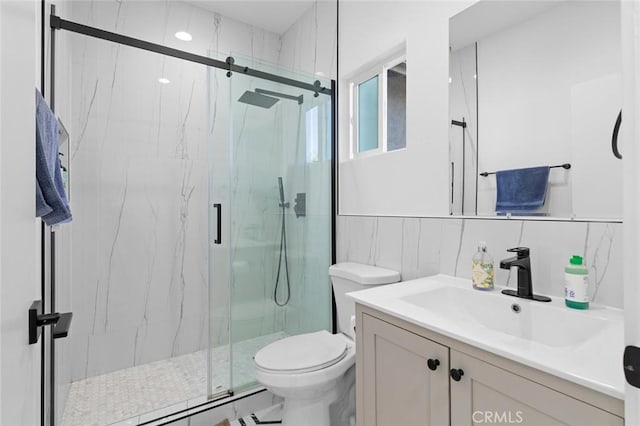 bathroom featuring vanity, toilet, tile walls, and a shower with shower door