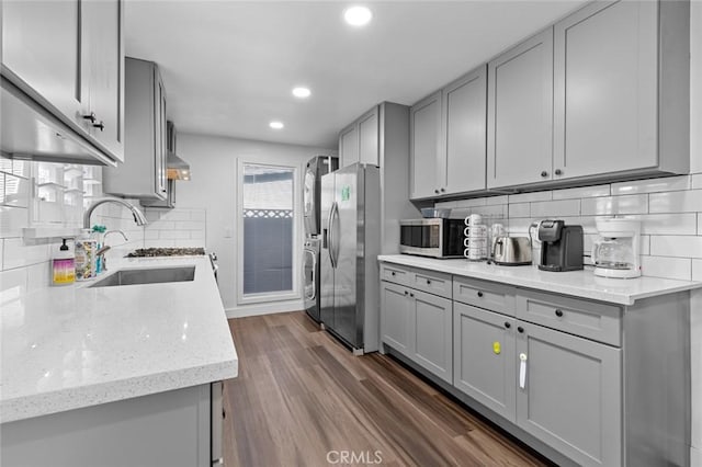 kitchen featuring backsplash, stainless steel appliances, gray cabinetry, and sink