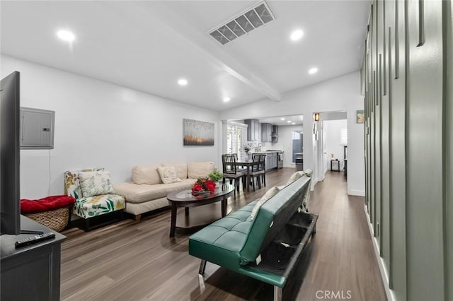 living room featuring lofted ceiling with beams, wood-type flooring, and electric panel