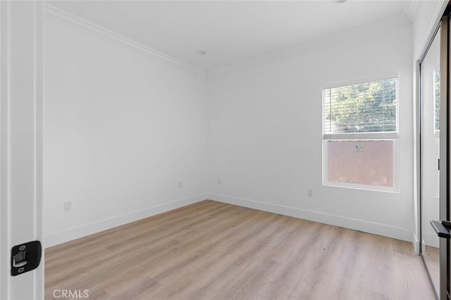 spare room with light wood-type flooring and crown molding