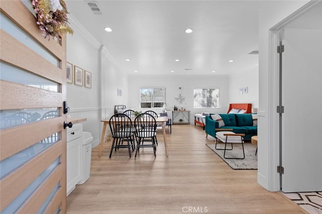 dining area with light hardwood / wood-style floors and ornamental molding