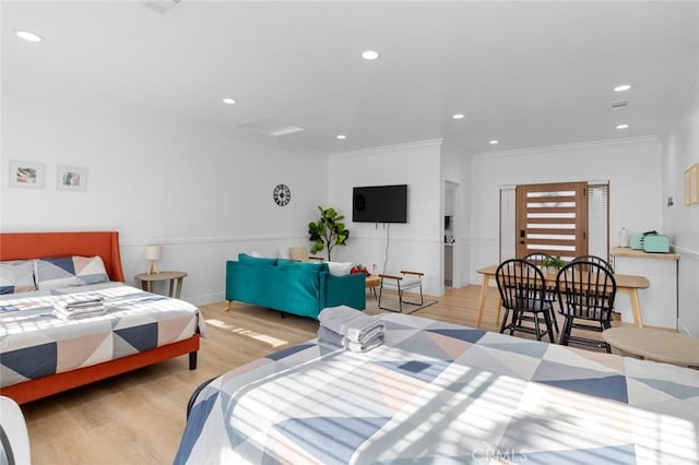 bedroom with light wood-type flooring and crown molding