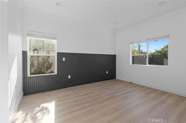 empty room with light hardwood / wood-style flooring and ornamental molding