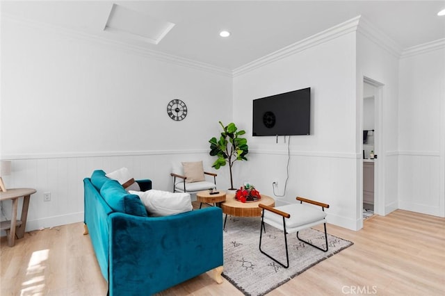 living room with light hardwood / wood-style flooring and ornamental molding