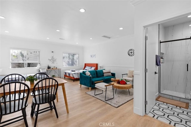 living room featuring plenty of natural light, light hardwood / wood-style floors, and crown molding