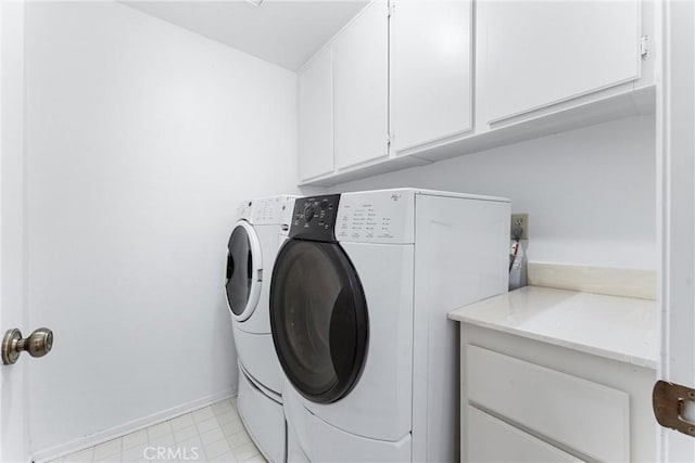 laundry area with washer and dryer and cabinets