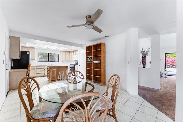 carpeted dining room with ceiling fan