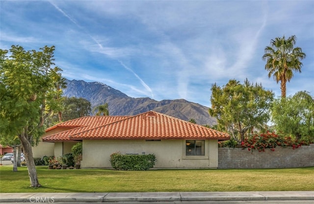 view of property exterior featuring a lawn and a mountain view