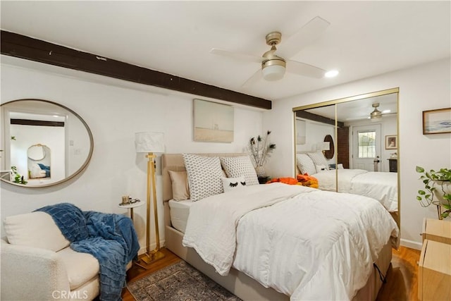 bedroom with a closet, beam ceiling, and ceiling fan