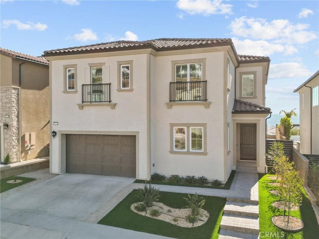 mediterranean / spanish home with a balcony and a garage