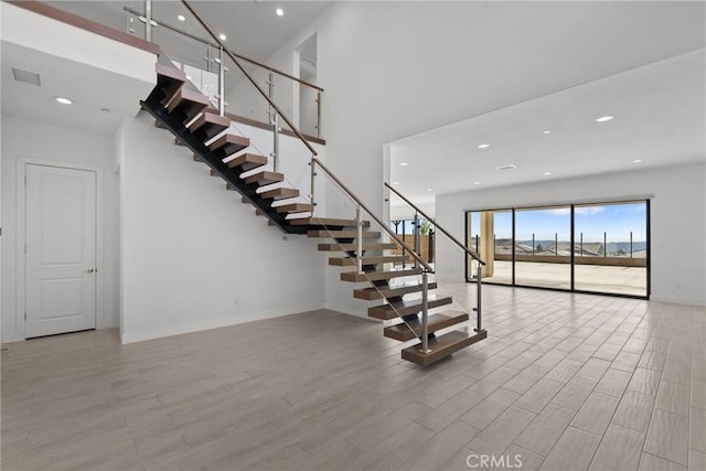 staircase featuring a towering ceiling