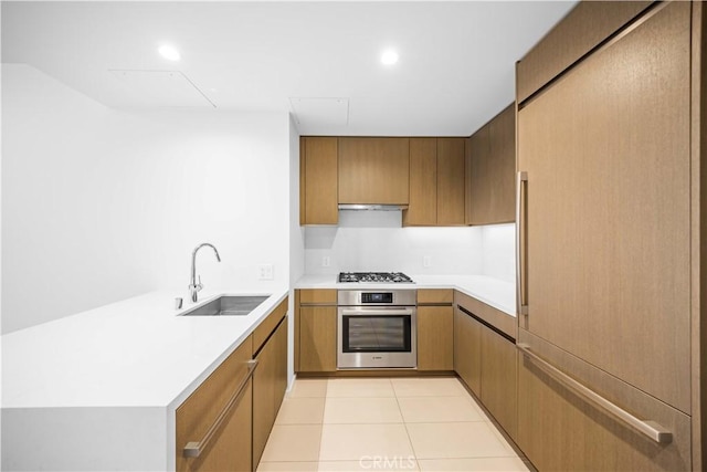 kitchen with range hood, light tile patterned floors, sink, and appliances with stainless steel finishes