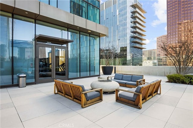 view of patio with an outdoor living space with a fire pit