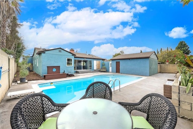 view of pool with a patio area and a diving board