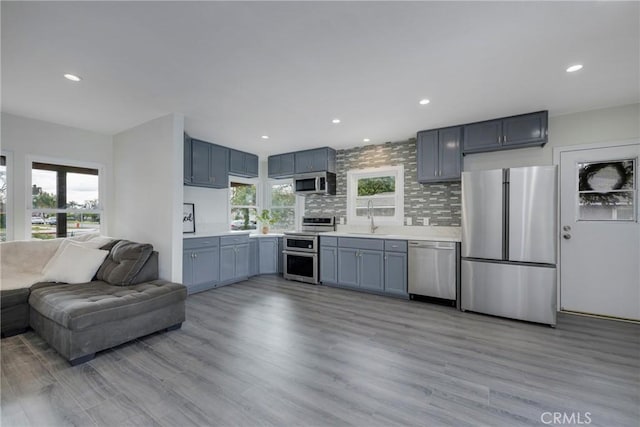 kitchen featuring stainless steel appliances, sink, a wealth of natural light, and decorative backsplash