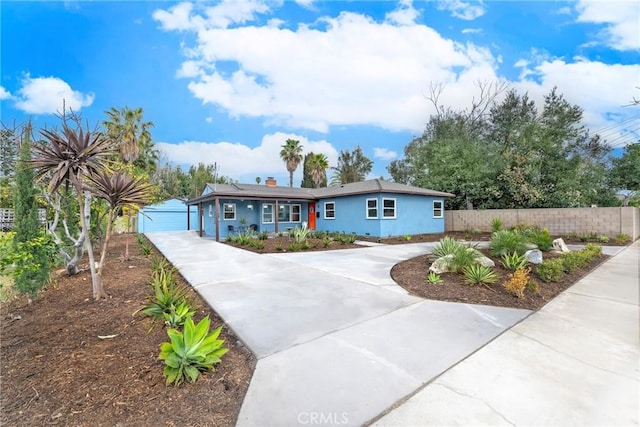 view of front of house featuring a garage, roof mounted solar panels, and fence