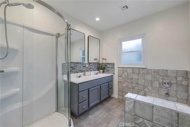 bathroom with tasteful backsplash, vanity, and shower with separate bathtub