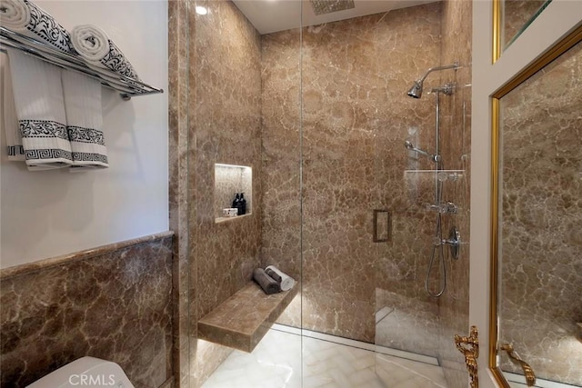 bathroom featuring toilet, tile walls, and a shower with shower door