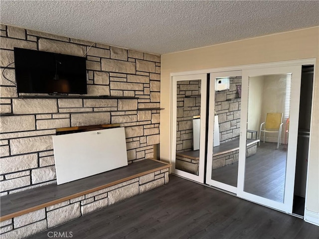 interior space with a textured ceiling and wood finished floors