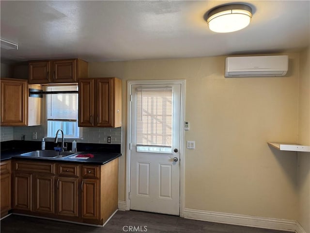 kitchen with backsplash, a wall mounted AC, dark wood-type flooring, and sink