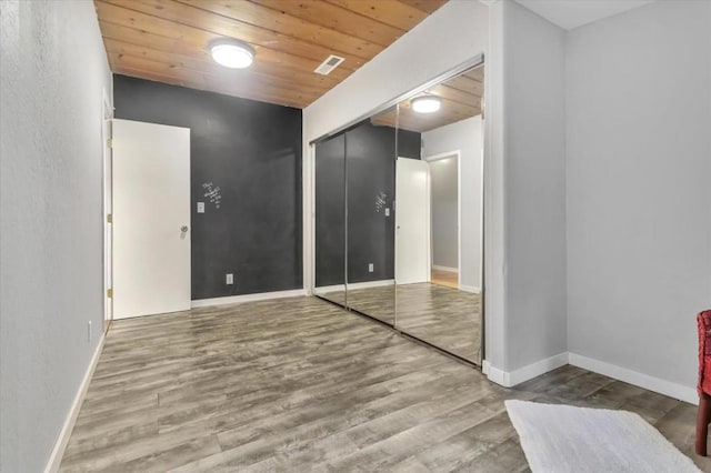 empty room with wooden ceiling and hardwood / wood-style flooring