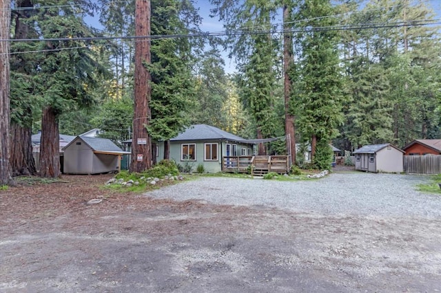 view of front of home with a storage unit and a wooden deck