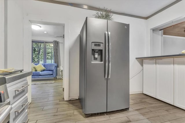 kitchen with white cabinetry and stainless steel fridge